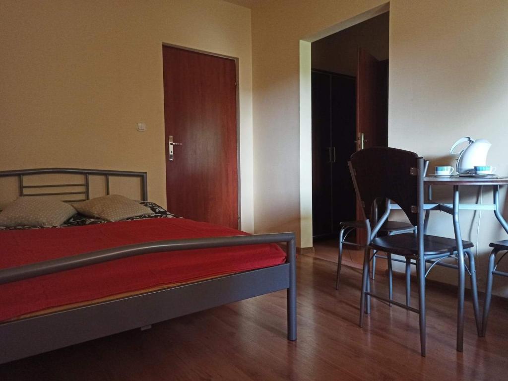 a bedroom with a bed and a table and chairs at Przylesie in Uniejow
