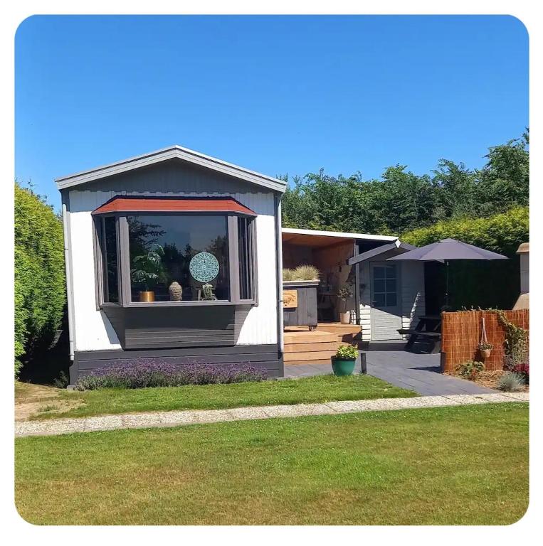 ein kleines Haus mit einem Fenster in einem Hof in der Unterkunft De Hooglander in Westergeest