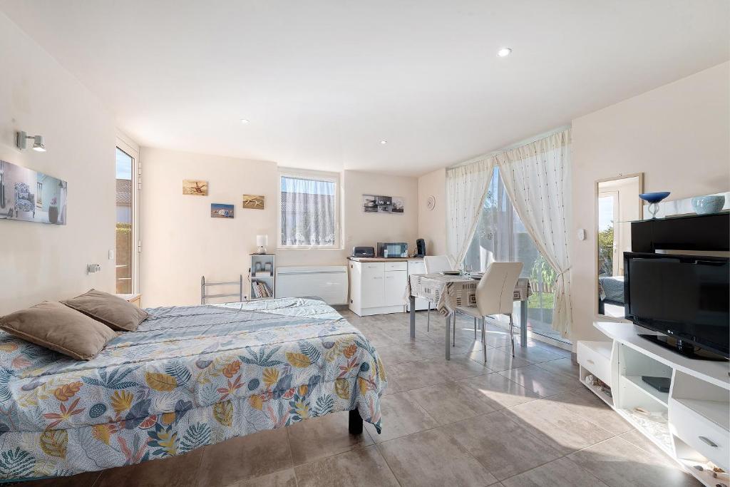 a bedroom with a bed and a desk with a television at Chambre d'hote chez Odile in Plougoulm