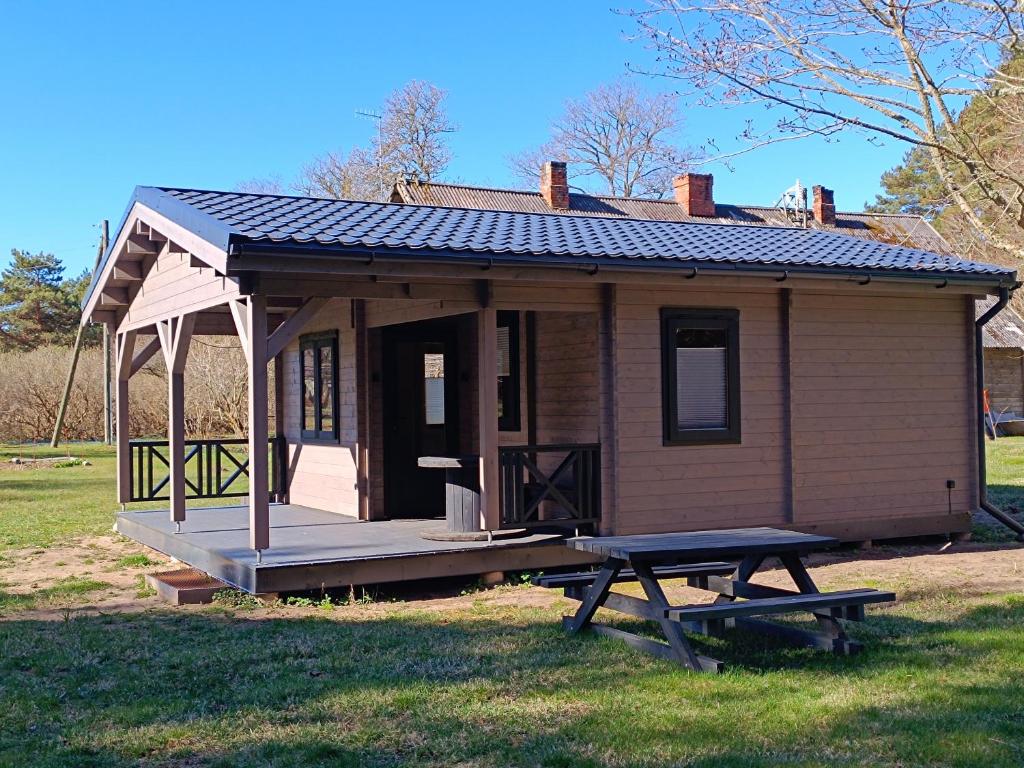 a small house with a picnic table in front of it at Mežmaļi in Jūrkalne