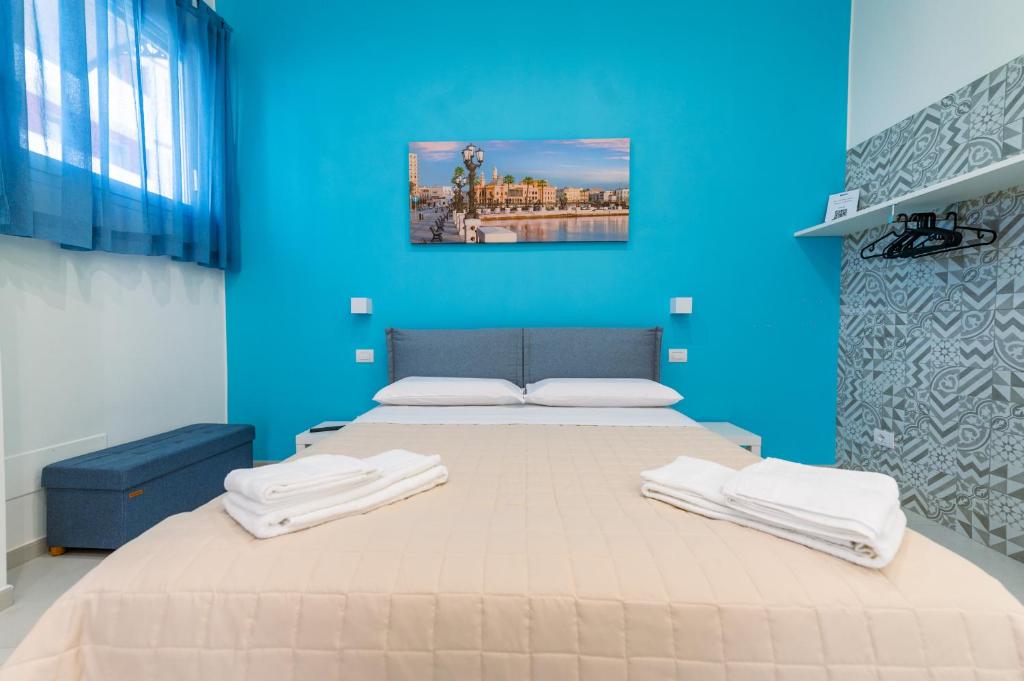 a blue room with a bed with towels on it at Sale e Salsedine in Bari