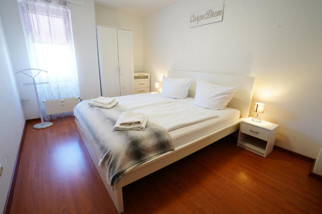 a bedroom with a bed with white sheets and white pillows at Radebeul Altkötzschenbroda in Radebeul