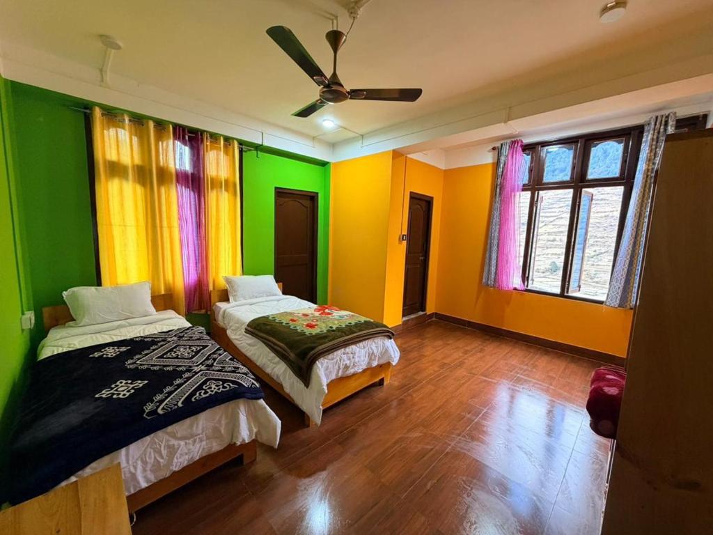 two beds in a room with colorful walls at Sangha Homestay in Dirang Dzong