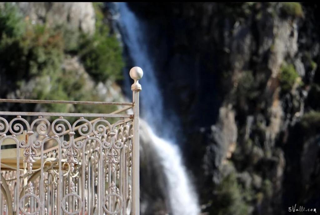 a metal railing with a waterfall in the background at La Casa Rosa in Pigna
