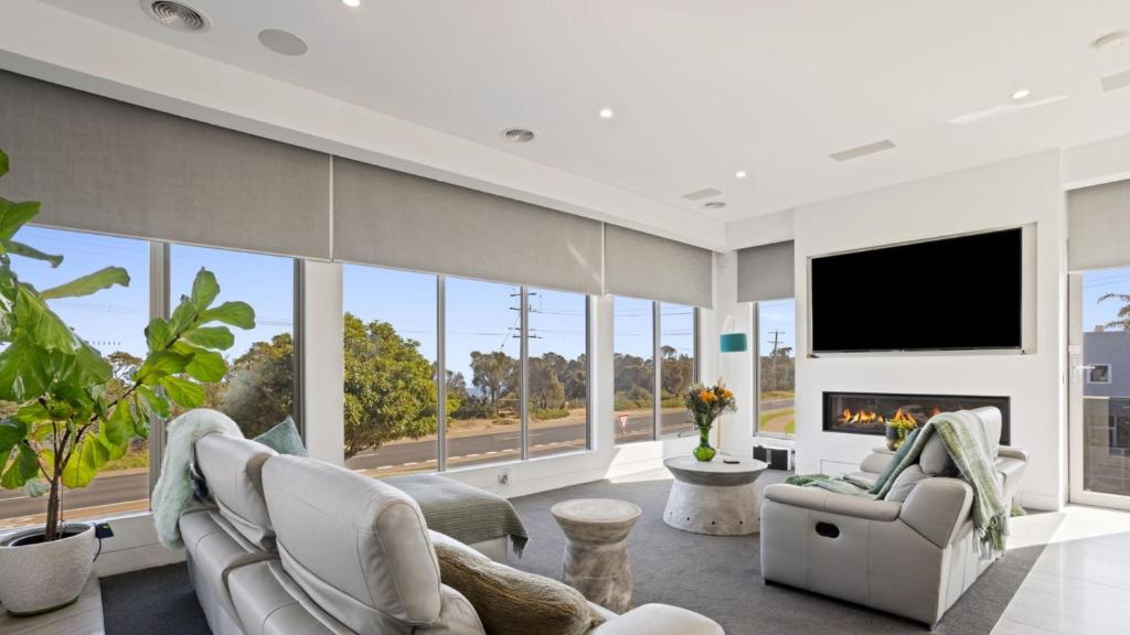 a living room with a fireplace and a tv at The Coral Esplanade in Mornington