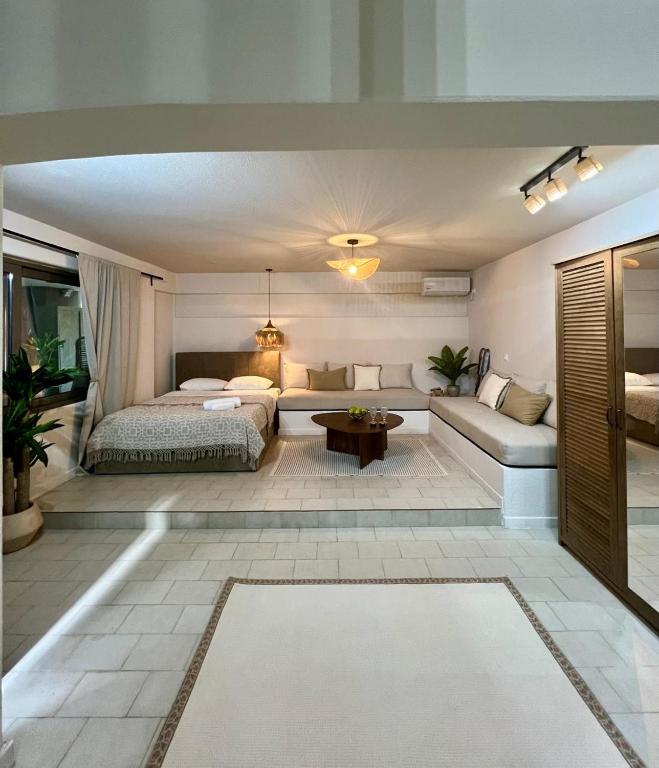 a living room with a bed and a couch at Modern & Cozy Studio for 2 in Saronida Steps from the Beach in Saronida