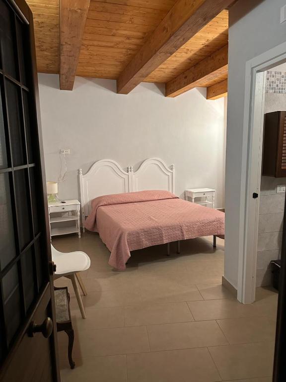 a bedroom with a bed with a pink blanket at IL CASTAGNETO Room in Pietraroia