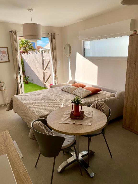 a bedroom with a bed and a table in front of a bed at Studio La Parenthèse Sablaise - 3 étoiles in Les Sables-d'Olonne