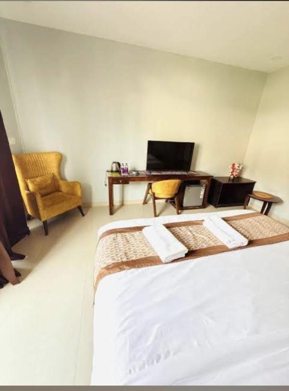a bedroom with a bed and a desk with a laptop at Tvessa-A Boutiqe Hotel in Mandrem