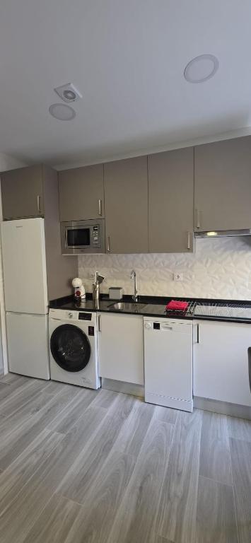 a kitchen with white cabinets and a sink at Tanez Garden Apartamentos in Madrid