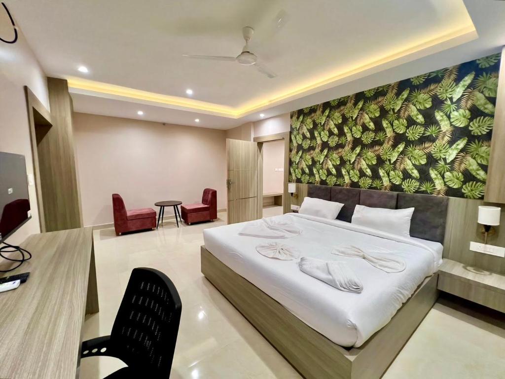 a bedroom with a large bed and a table and chairs at Hotel Airport View in Pāsighāt