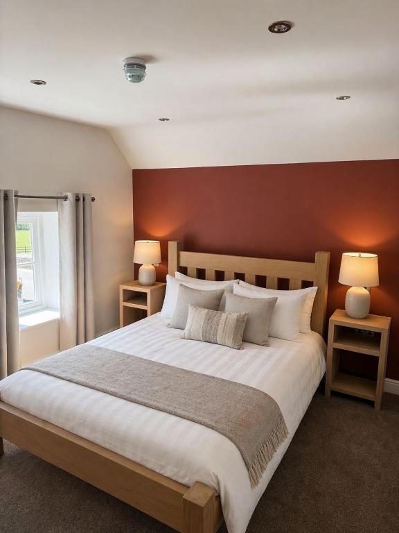 a bedroom with a large bed with a red wall at The Hurt Arms in Whatstandwell