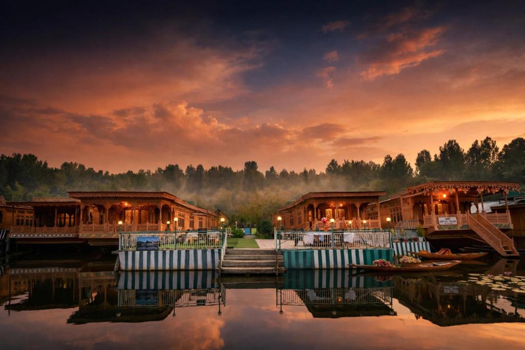 a group of houses on the water at sunset at Firdous Houseboats at Dal Lake in Srinagar