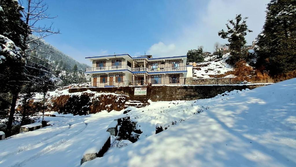 a house on top of a snow covered mountain at Vikas Hotel And Restaurant in Barot 