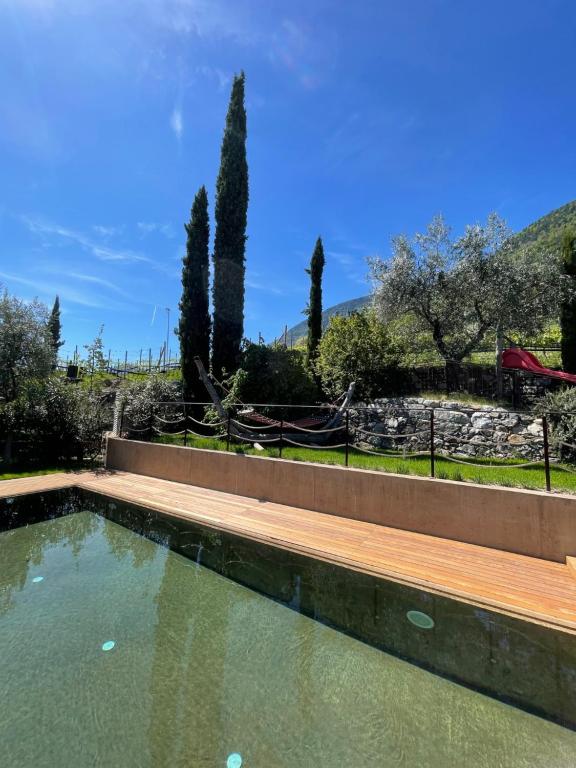 a swimming pool in a garden with a wooden deck at Füchslhof in Marlengo