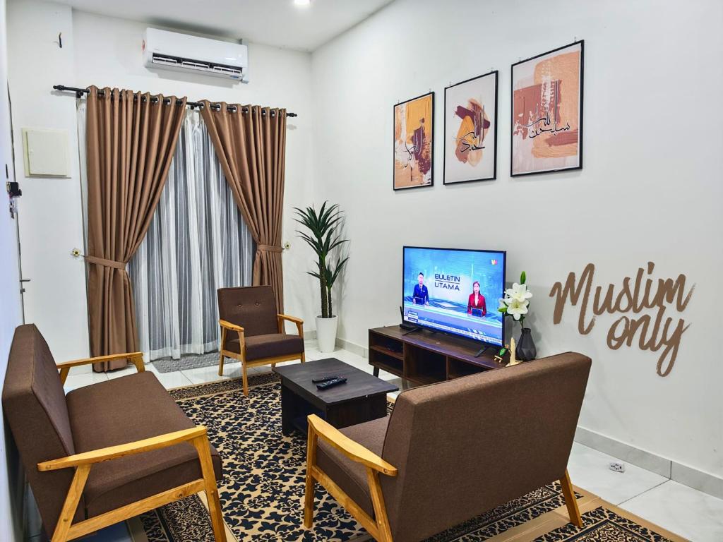a living room with two chairs and a television at Homestay Seri Damai in Juasseh
