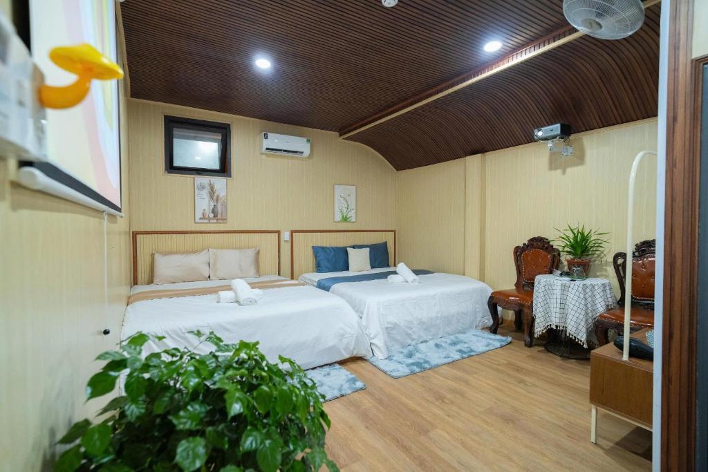 a bedroom with two beds and a table at Home Đăng Hải in Phú Hiệp