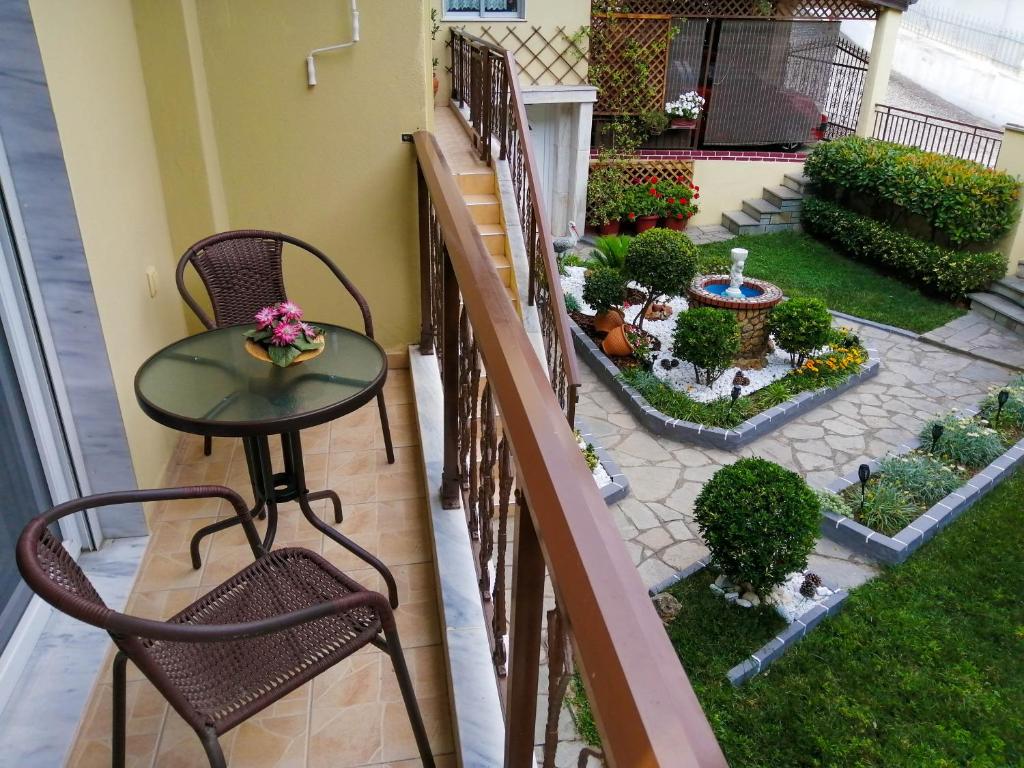 a balcony with a table and chairs and a garden at Filomeni's house in Kavála