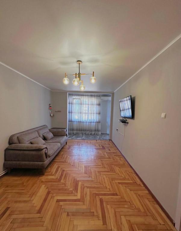 a living room with a couch and a hard wood floor at дом отдыха in Itʼkhvisi