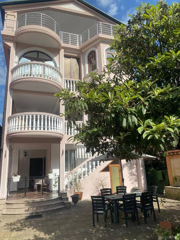 a house with a table and chairs in front of it at "Ламази"Домашняя гостиница in Kobuleti