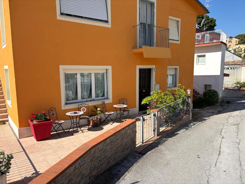 a patio with tables and chairs in front of a building at Casa Linda, a due passi dal mare in Numana