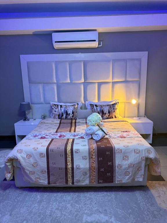 a bedroom with a large bed with a large headboard at Acomodações e Serviços TR in Maputo