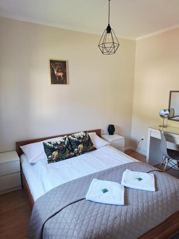 a bedroom with a bed with two towels on it at Pokoje Gościnne Perła in Brenna