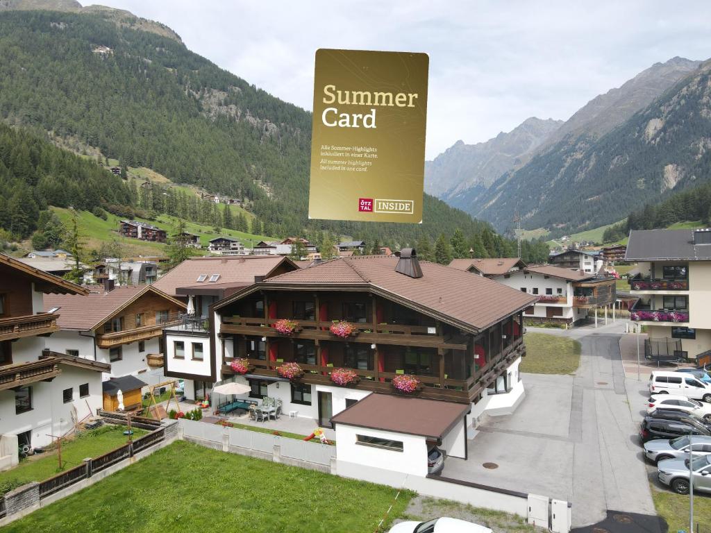 a sign on top of a building in a village at Hotel Garni Maria Theresia - Official Ötztal Summer Card Partner in Sölden