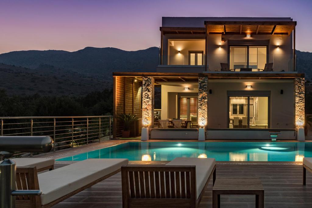 エロウンダにあるElounda Spa Villa Crete - Ultimate Luxury Resortの家の前にスイミングプールがある家