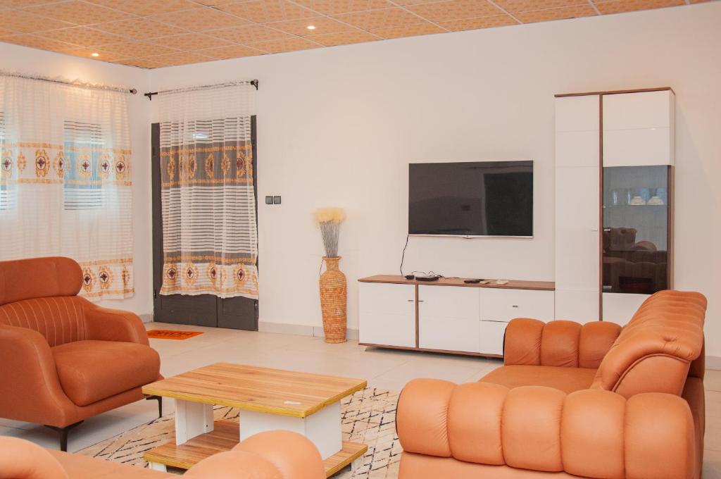 a living room with two chairs and a tv at Résidence Maranatha in Cotonou