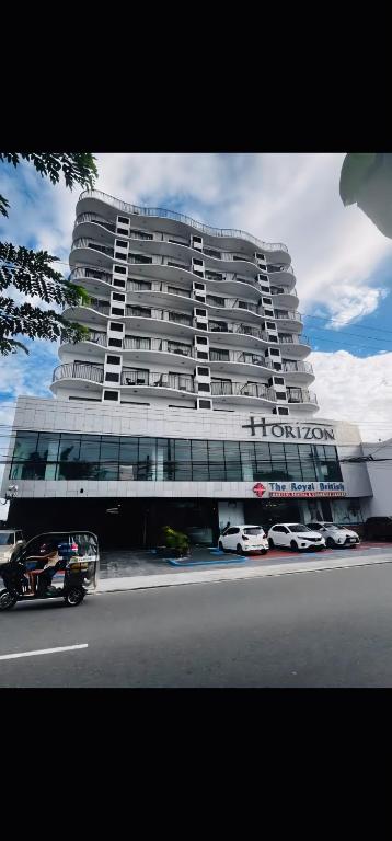 a large building with cars parked in front of it at A cozy and spacious Studio apartment Angeles city pampanga in Angeles