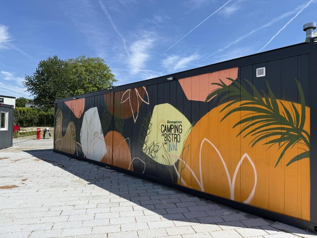 a wall with a painting of a palm tree on it at Baumgartner Camping am Inn in Schärding