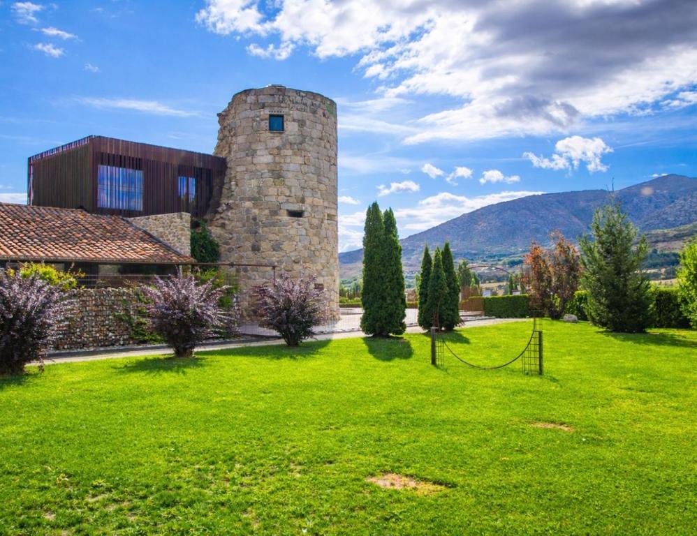 a building in a field with a grassy yard at Belle Torre Mayorazgo Boutique Hotel in Villatoro