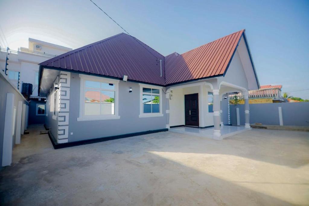 a house with a red roof and a driveway at Zanzibar Residence in Zanzibar City