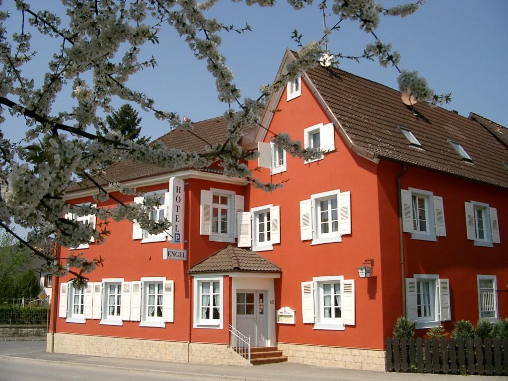 ein rotes Haus mit weißen Fenstern in der Unterkunft Gasthof Engel in Müllheim