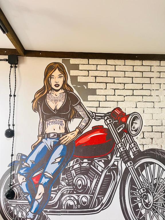 a painting of a woman sitting on a motorcycle at Лофт в самом сердце Караганды in Karagandy