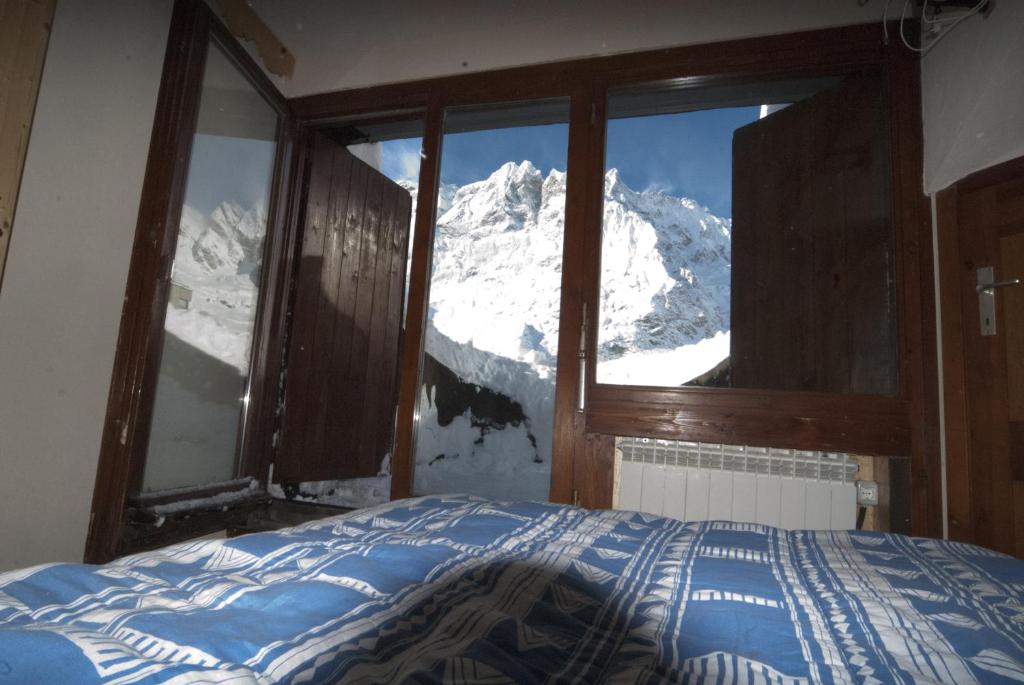 a bedroom with a view of a snow covered mountain at Piolet Panoramic Apartments in Breuil-Cervinia