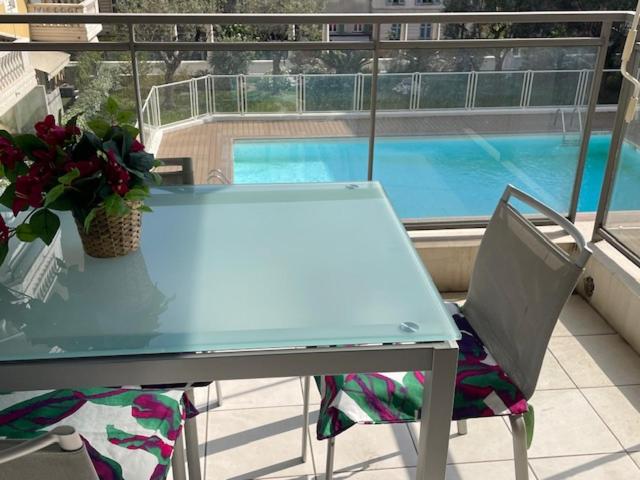 a blue table and chairs on a balcony with a swimming pool at Dolce Vita à Nice in Nice