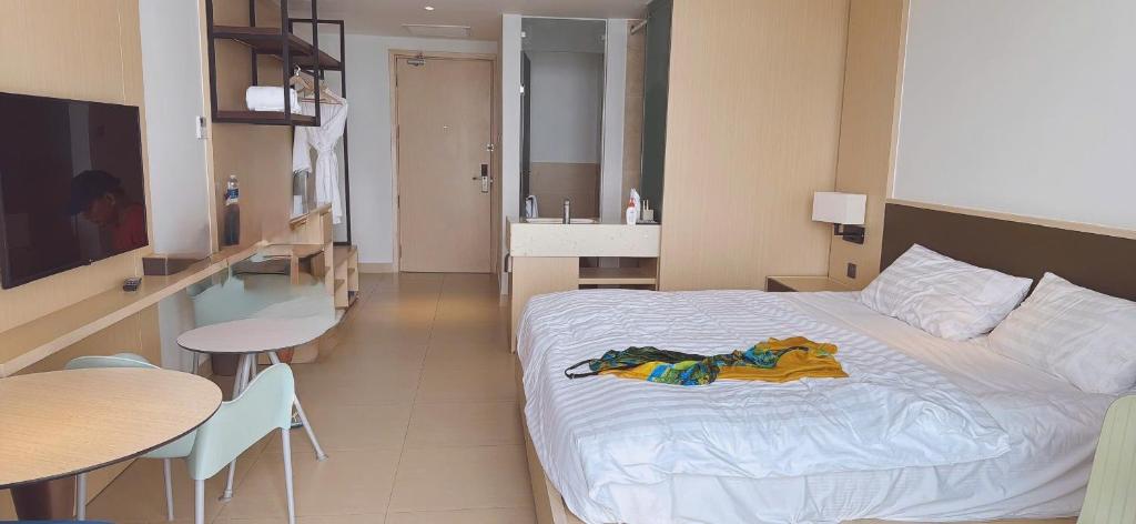 a bedroom with a bed and a kitchen and a table at Hà Lịch Light B0719 in Cam Ranh International Airport