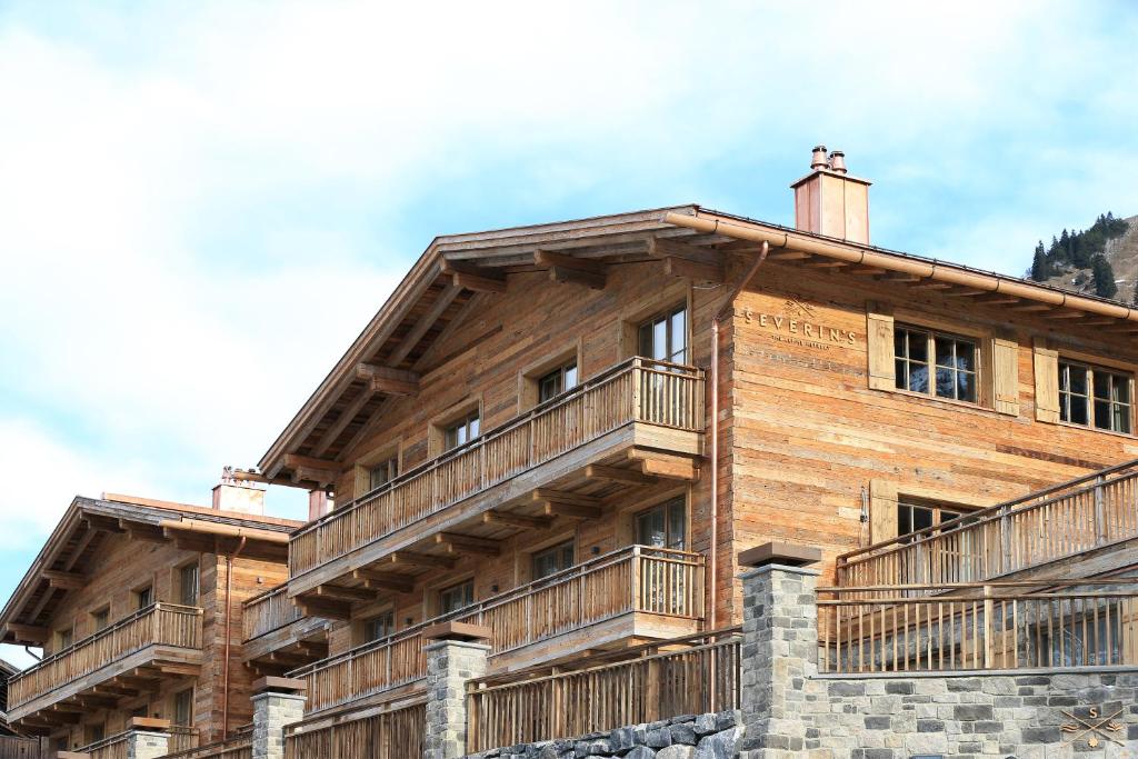 レッヒにあるSEVERIN*S – The Alpine Retreatのバルコニー付きの大きな木造の建物