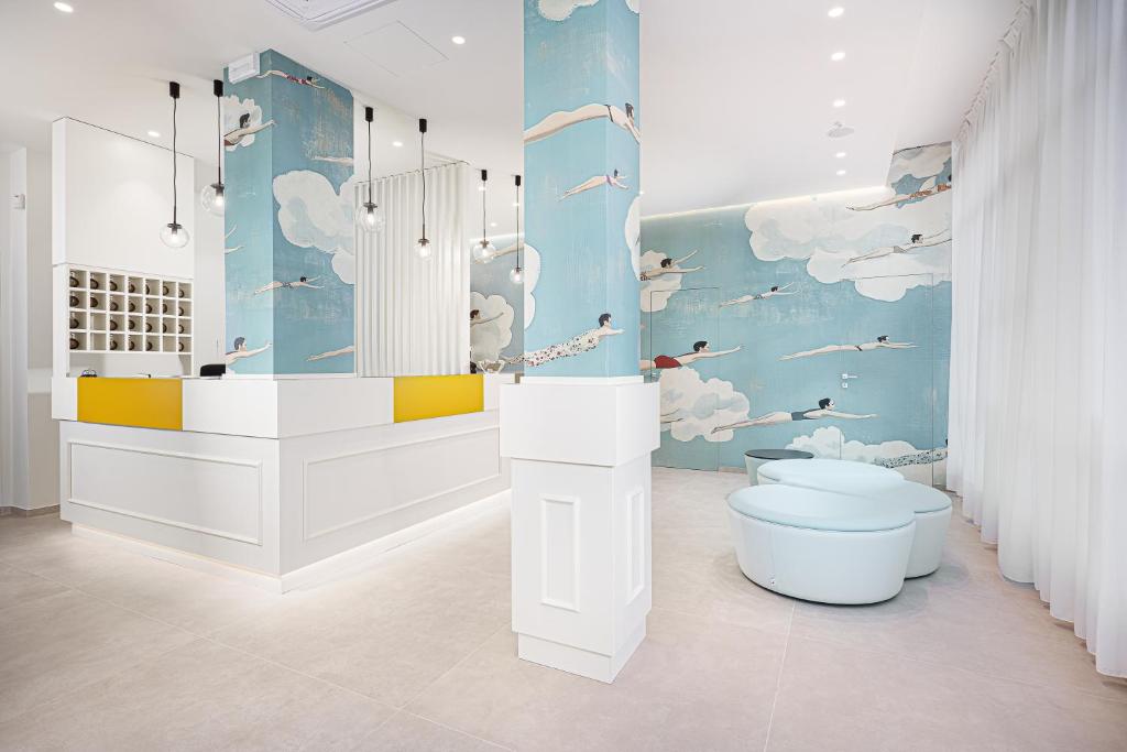 a bathroom with a toilet and clouds painted on the wall at Hotel Geminus B&B in Cesenatico