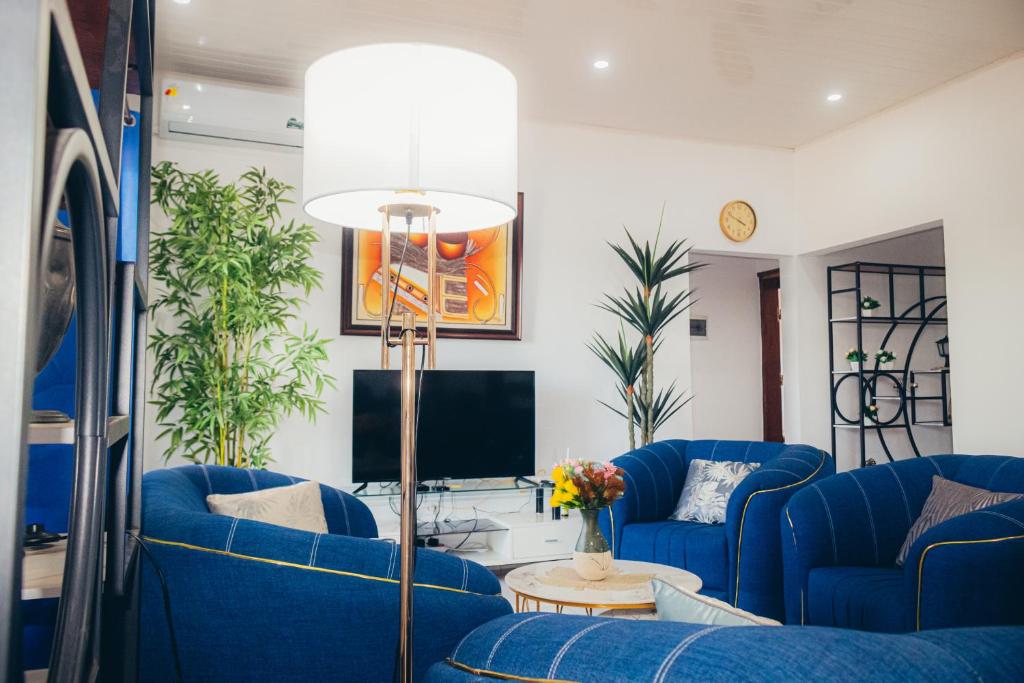 a living room with blue couches and a tv at L'appartement Bleu d'Assinie in Assinie