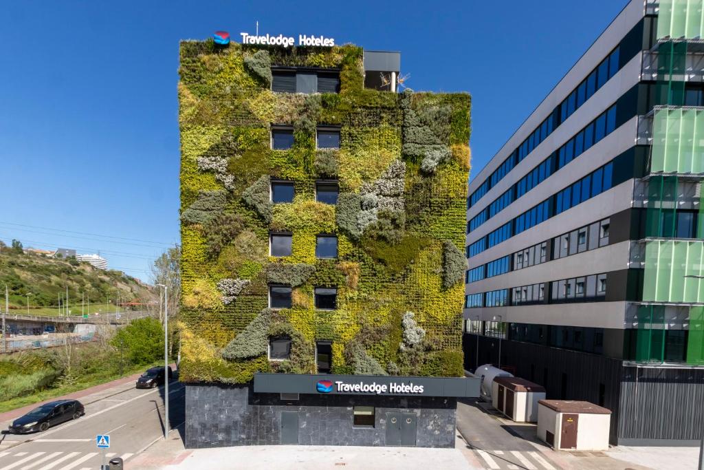 a building with green ivy on the side of it at Travelodge Bilbao Sestao in Sestao