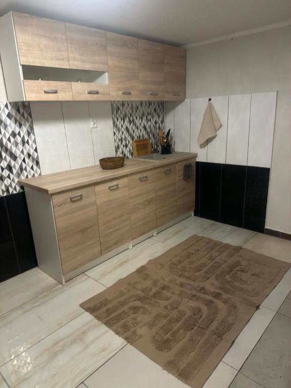 a kitchen with wooden cabinets and a large rug at NA SKARPIE in Łomża