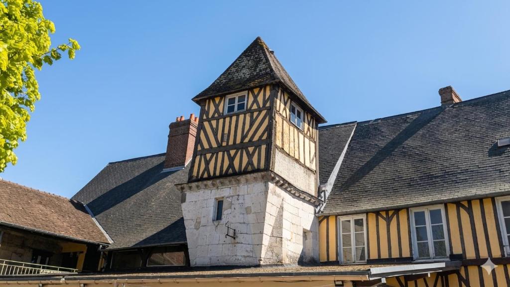 an old building with a clock tower on top of it at L'Authentique in Beaumont-le-Roger