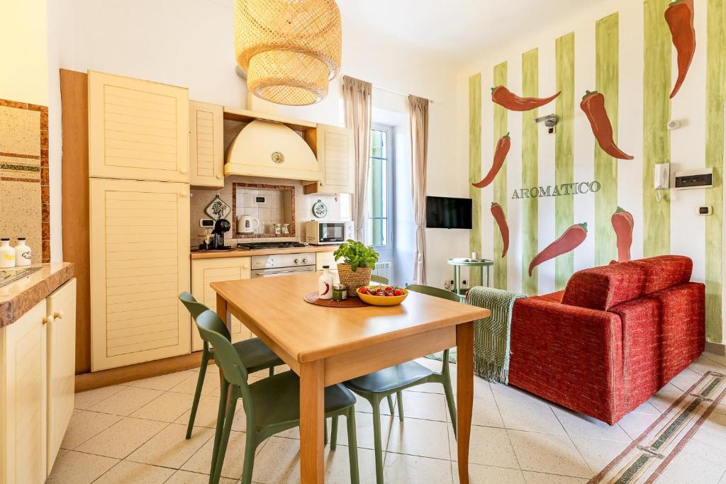 a kitchen and dining room with a table and a red chair at Aromatico design 2 camere da letto / centralissimo in Diano Marina