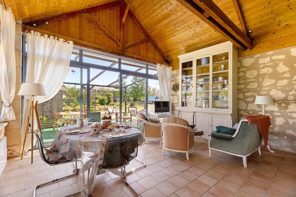 a large living room with a table and chairs at Le Grand Pré du Clos Champêtre in Longué