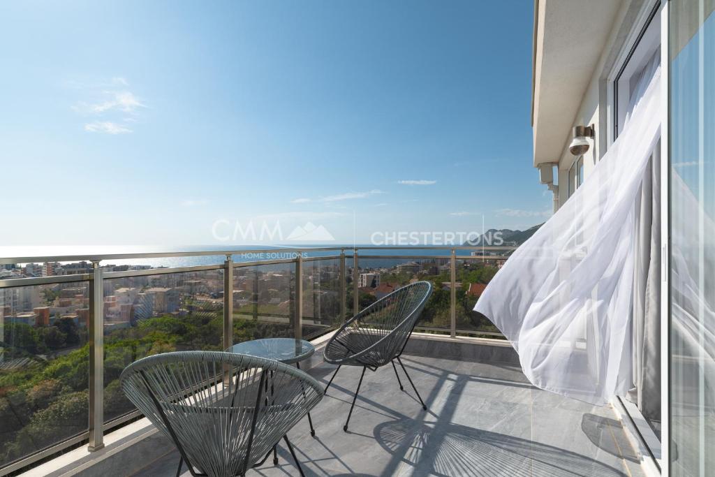 a balcony with two chairs and a view of the city at Elegant Seaview 1bd in Dobre Vode in Dobra Voda