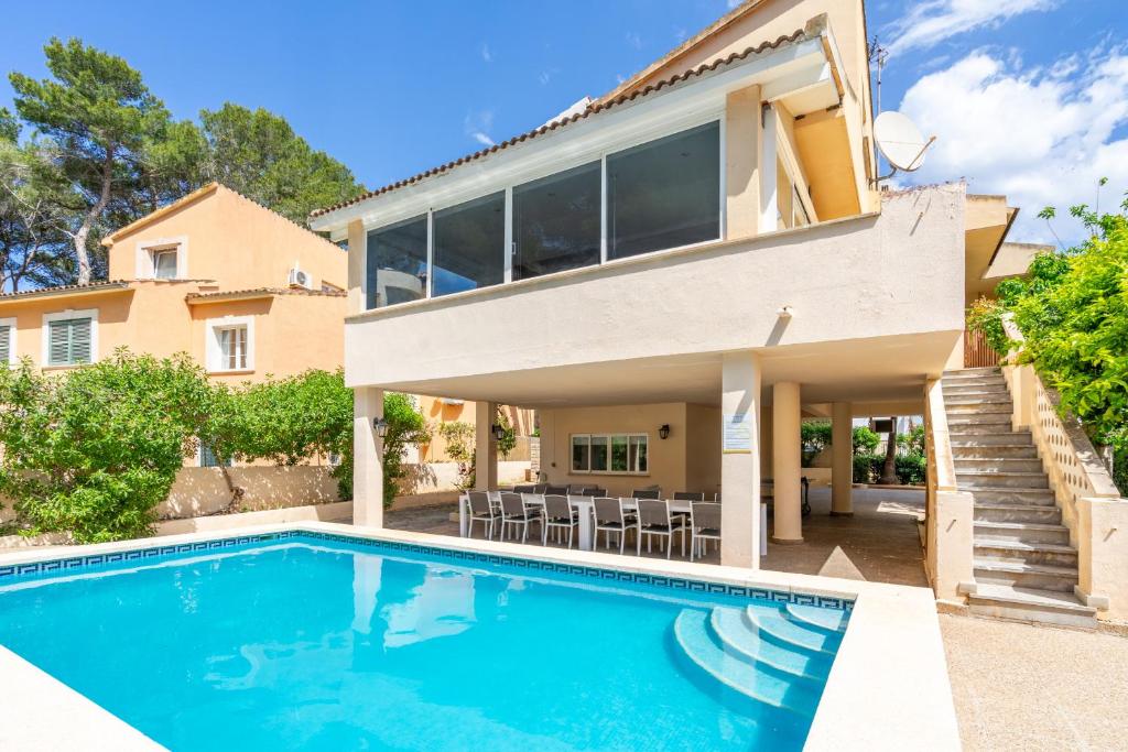 a home with a swimming pool in front of a house at Villa Arenas in El Arenal