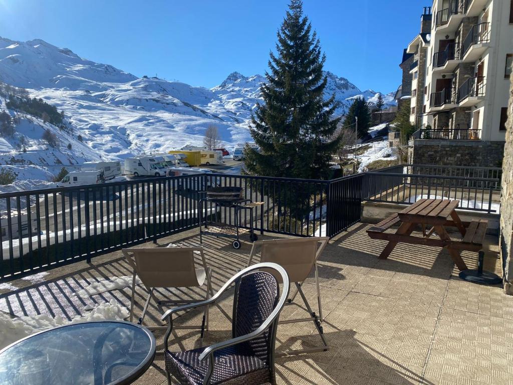 a table and chairs on a balcony with a mountain at Ibon de Anayet in Formigal